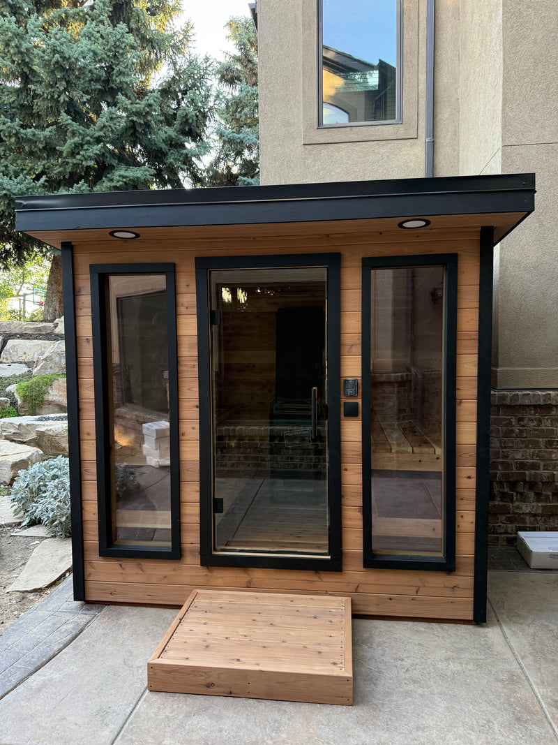 Timberline Lux front view with glass doors, black trim and a cedar step on a patio