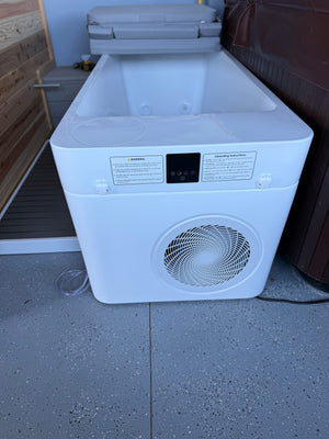 Cold plunge tub with folded cover beside a cedar sauna and step platform