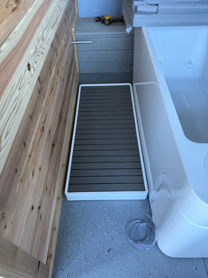 Cold plunge tub and step platform set up beside a cedar sauna