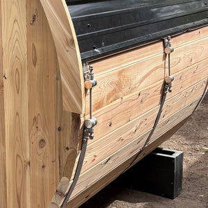 Close-up of Sugi cedar barrel staves and metal tension band hardware on a Blazin Saunas barrel