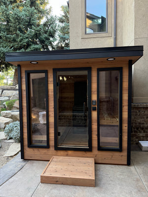 Timberline Lux glass front and black flat roof beside a stone house