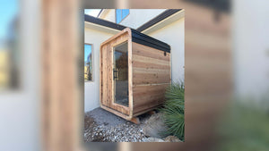 2 Person Blazin Sauna Pod in Sugi cedar with a glass door beside a home